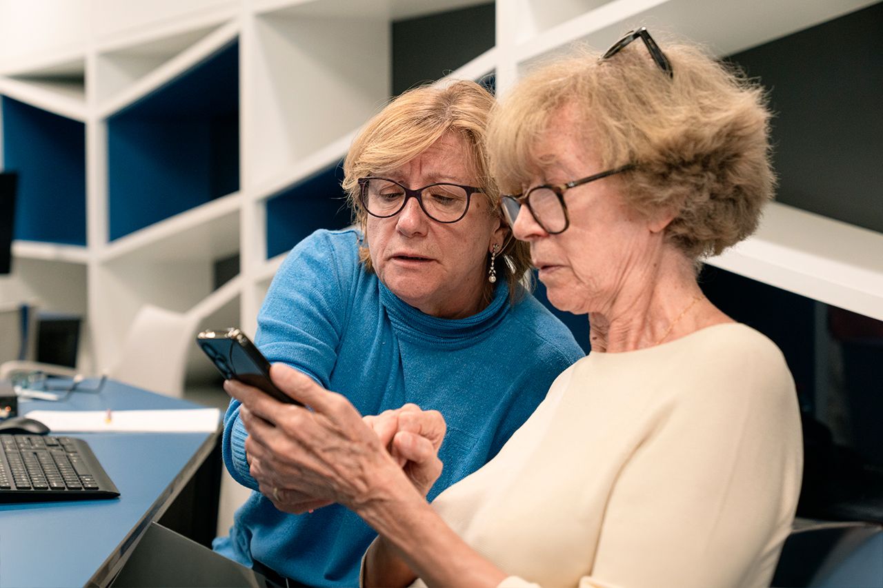 Dos señoras aprenden a utilizar un smartphone durante los talleres Competencias Digitales +60. © Fundación ”la Caixa”